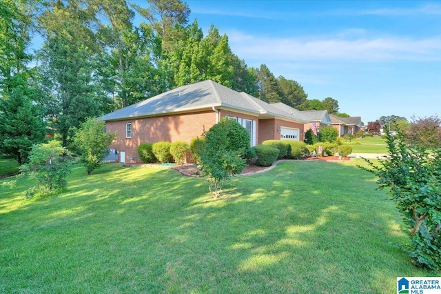 617 Golden Eagle Cir, Jasper, AL 35504 - view of side of property with an attached garage, a lawn, and brick siding