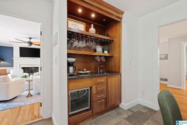 3208 N Woodridge Rd, Mountain Brook, AL 35223 - indoor wet bar with ceiling fan, baseboards, a fireplace, wine cooler, and crown molding