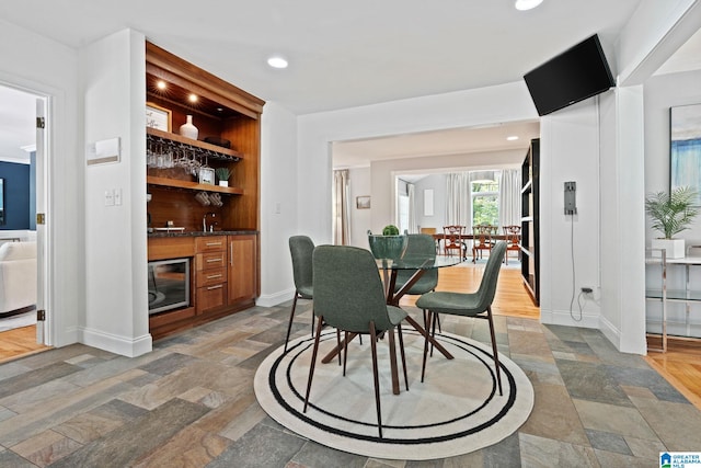 3208 N Woodridge Rd, Mountain Brook, AL 35223 - dining space featuring wet bar, baseboards, recessed lighting, and stone finish flooring