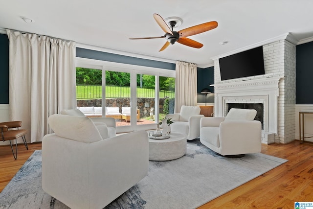 3208 N Woodridge Rd, Mountain Brook, AL 35223 - living area with ceiling fan, wood finished floors, crown molding, and a brick fireplace