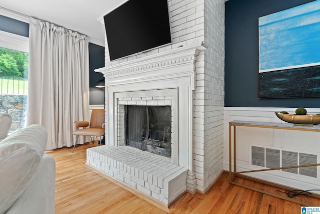 3208 N Woodridge Rd, Mountain Brook, AL 35223 - living room featuring wainscoting, wood finished floors, and a brick fireplace