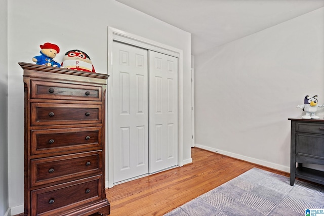 3208 N Woodridge Rd, Mountain Brook, AL 35223 - bedroom with light wood-type flooring, baseboards, and a closet