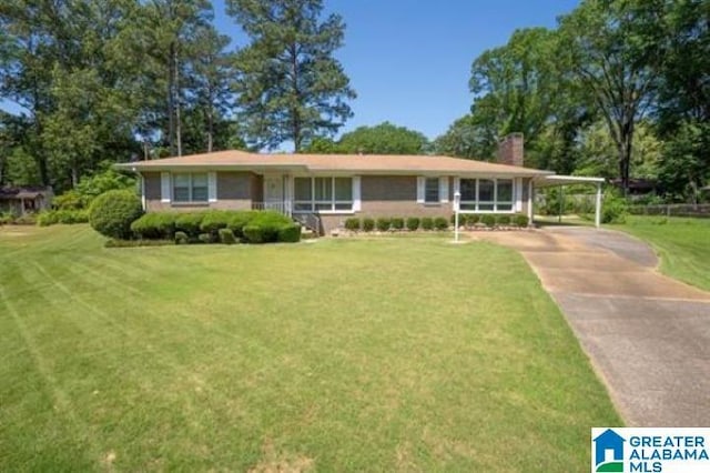 3332 Berry Dr, Hueytown, AL 35023 - view of front of property with a front yard, a carport, driveway, and a chimney