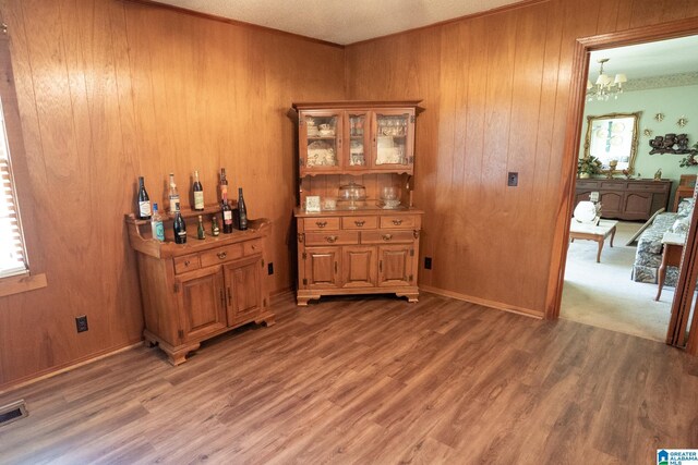 3332 Berry Dr, Hueytown, AL 35023 - bar with a chandelier, wood walls, and light wood-style floors