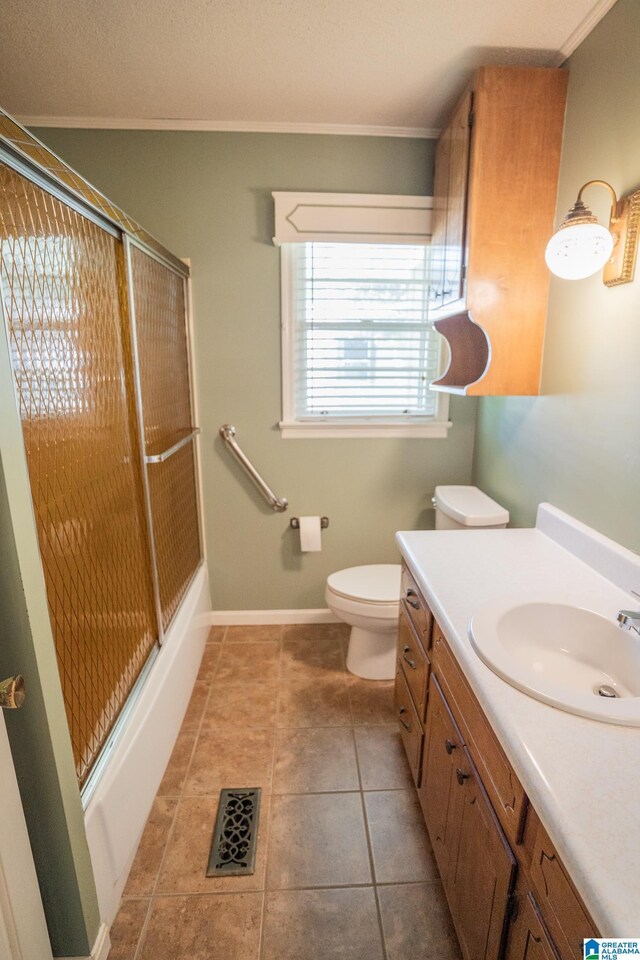 3332 Berry Dr, Hueytown, AL 35023 - full bathroom featuring ornamental molding, vanity, toilet, shower / bath combination with glass door, and tile patterned flooring
