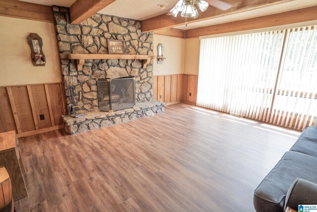 3332 Berry Dr, Hueytown, AL 35023 - unfurnished living room featuring a wainscoted wall, a ceiling fan, beamed ceiling, wood finished floors, and a fireplace