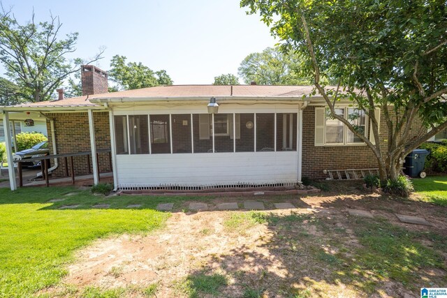 3332 Berry Dr, Hueytown, AL 35023 - back of property featuring a chimney, brick siding, a sunroom, and a yard