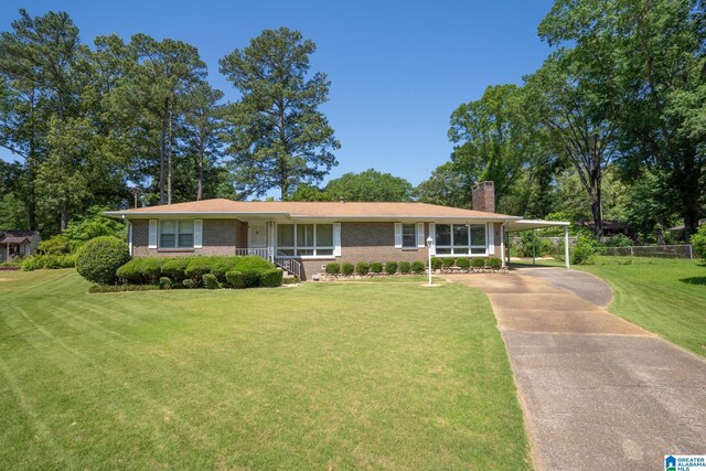 3332 Berry Dr, Hueytown, AL 35023 - view of front of home with a chimney, driveway, brick siding, and a carport