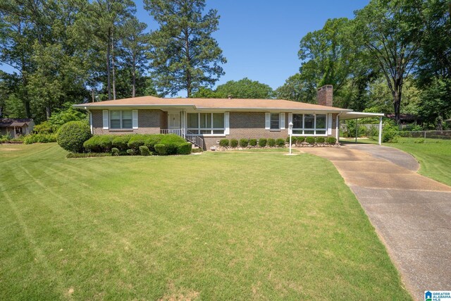 3332 Berry Dr, Hueytown, AL 35023 - view of front of property featuring a chimney, a front lawn, brick siding, a carport, and concrete driveway