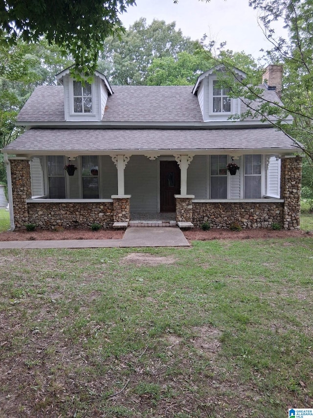 2120 Brewster Rd, Birmingham, AL 35235 - view of front facade featuring stone siding, a front lawn, covered porch, and a chimney