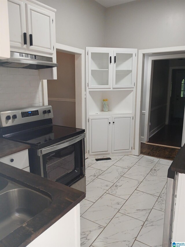 2120 Brewster Rd, Birmingham, AL 35235 - kitchen featuring stainless steel electric stove, under cabinet range hood, dark countertops, and white cabinets