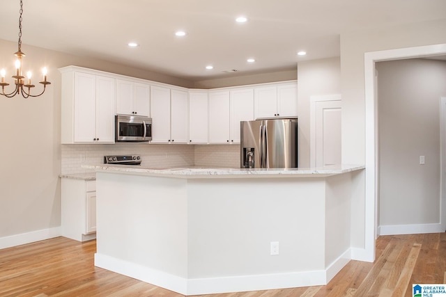 126 Harbor Pointe Dr, Talladega, AL 35160 - kitchen with appliances with stainless steel finishes, backsplash, light wood-style flooring, white cabinetry, and recessed lighting