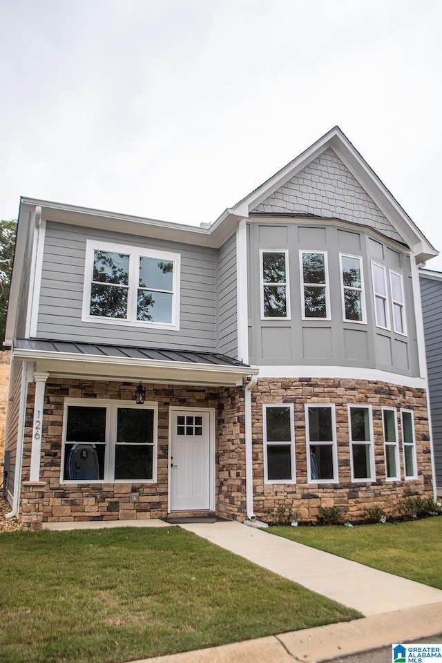 126 Harbor Pointe Dr, Talladega, AL 35160 - view of front of property featuring a front lawn, a standing seam roof, stone siding, and a metal roof