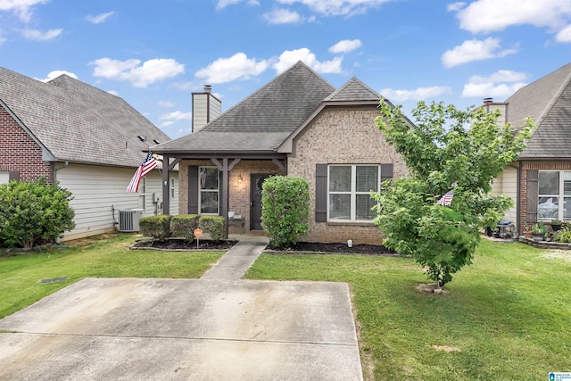 1206 Savannah Ln, Calera, AL 35040 - view of front of property featuring cooling unit, brick siding, a chimney, and a front lawn