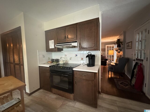 400 Shiloh Cir, Birmingham, AL 35213 - kitchen featuring black range with electric cooktop, under cabinet range hood, light countertops, dark brown cabinets, and tasteful backsplash