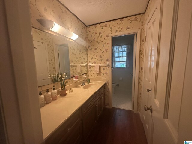 400 Shiloh Cir, Birmingham, AL 35213 - bathroom with wallpapered walls, wood finished floors, toilet, vanity, and a textured ceiling