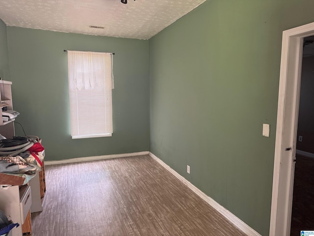 1015 Anderson Rd, Gadsden, AL 35901 - unfurnished bedroom with a textured ceiling, wood finished floors, and baseboards