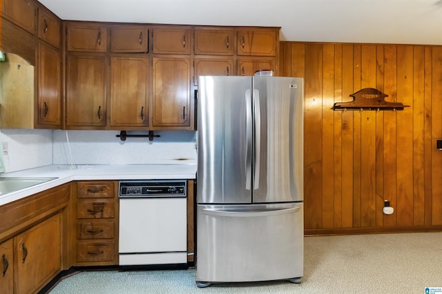 2424 Debbie Dr, Center Point, AL 35215 - kitchen featuring freestanding refrigerator, dishwasher, light countertops, brown cabinets, and wood walls