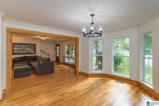 1794 Riverknolle Rd, Tallassee, AL 36078 - unfurnished living room with light wood-type flooring, a chandelier, crown molding, stairway, and healthy amount of natural light