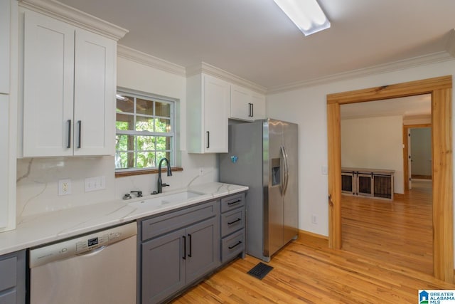 1794 Riverknolle Rd, Tallassee, AL 36078 - kitchen featuring stainless steel appliances, a sink, gray cabinetry, light wood-type flooring, and ornamental molding