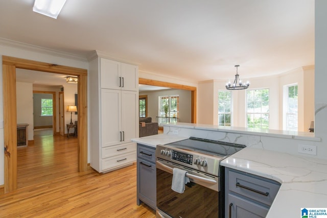 1794 Riverknolle Rd, Tallassee, AL 36078 - kitchen with stainless steel electric range oven, light wood-type flooring, white cabinets, crown molding, and light stone countertops