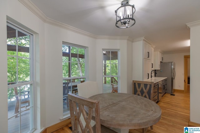 1794 Riverknolle Rd, Tallassee, AL 36078 - dining area featuring a chandelier, ornamental molding, light wood-type flooring, and baseboards