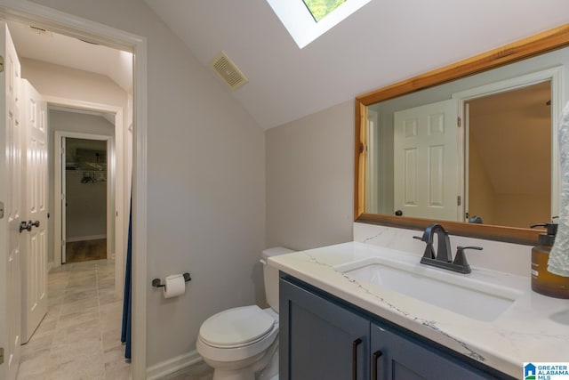 1794 Riverknolle Rd, Tallassee, AL 36078 - bathroom with lofted ceiling, vanity, toilet, a skylight, and baseboards
