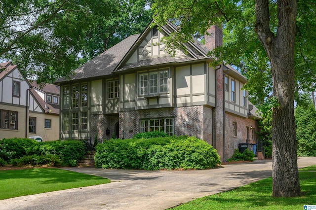 312 La Playa Pl, Homewood, AL 35209 - tudor-style house with stucco siding, brick siding, a chimney, and roof with shingles