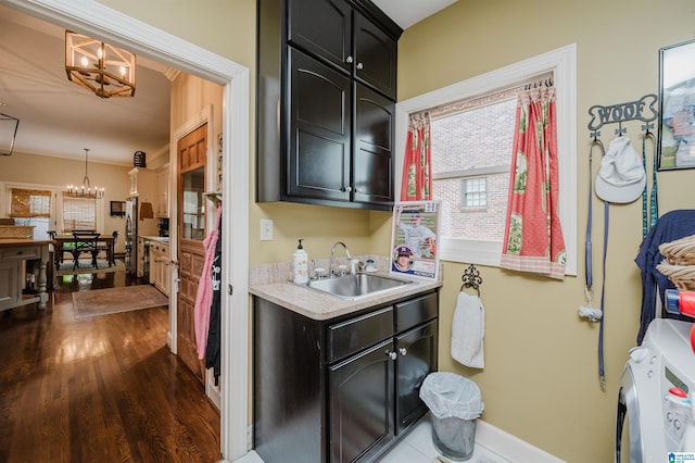312 La Playa Pl, Homewood, AL 35209 - laundry room with a chandelier, cabinet space, dark wood-type flooring, washer and clothes dryer, and baseboards