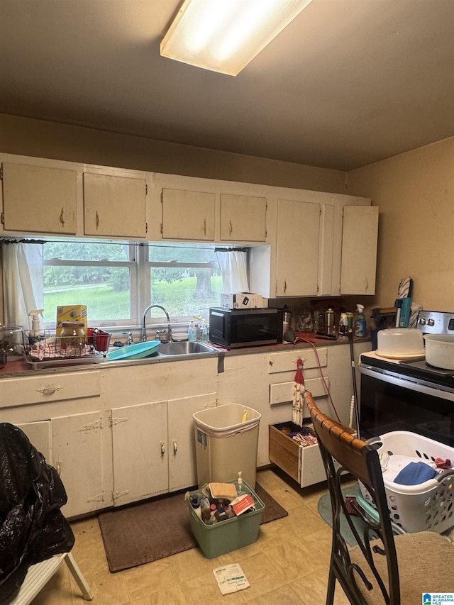9709 Mize Rd, Remlap, AL 35133 - kitchen with black microwave, a sink, white cabinets, and light floors