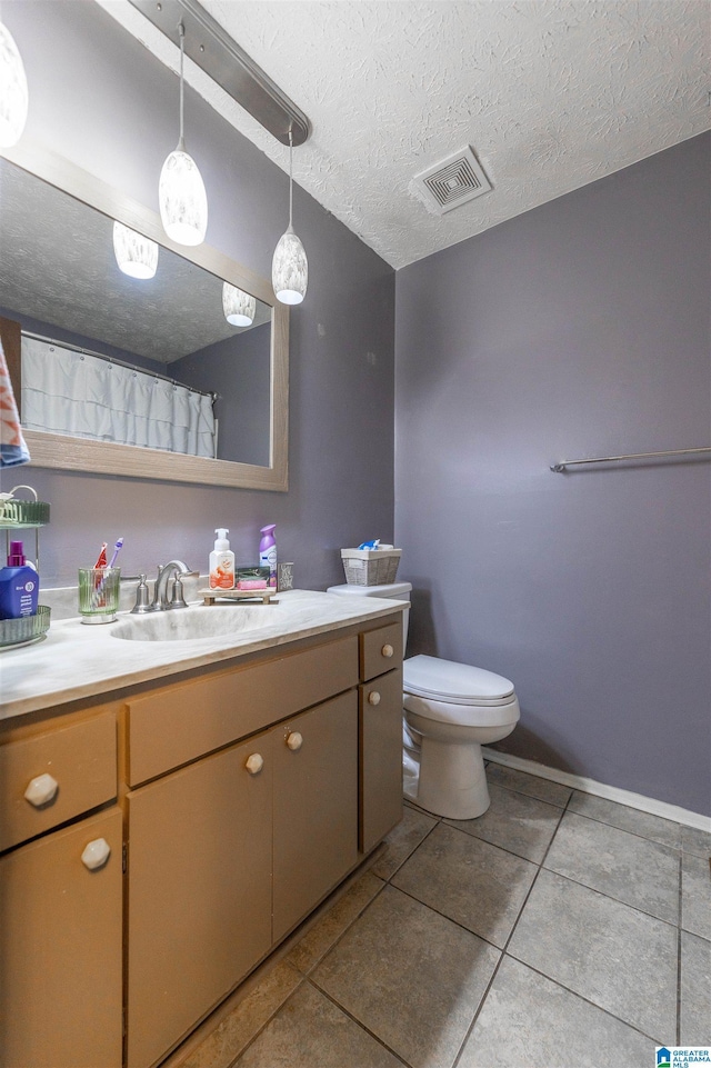1214 Wildoak Dr, Anniston, AL 36206 - bathroom with vanity, tile patterned flooring, toilet, and a textured ceiling