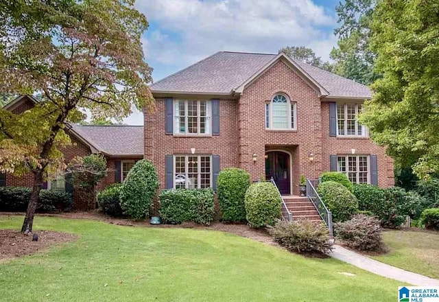 2563 Aspen Cove Dr, Vestavia Hills, AL 35243 - colonial house featuring a front yard, brick siding, and a shingled roof