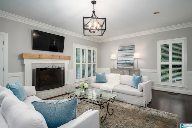 2563 Aspen Cove Dr, Vestavia Hills, AL 35243 - living room featuring crown molding, a chandelier, wood finished floors, a wainscoted wall, and a brick fireplace