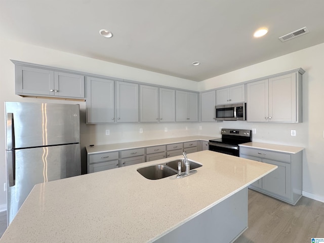 115 Ridgeview Cir, Jemison, AL 35085 - kitchen featuring stainless steel appliances, gray cabinetry, a sink, light wood-type flooring, and light stone counters