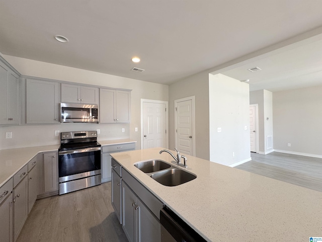 115 Ridgeview Cir, Jemison, AL 35085 - kitchen with appliances with stainless steel finishes, a sink, light wood finished floors, gray cabinetry, and recessed lighting
