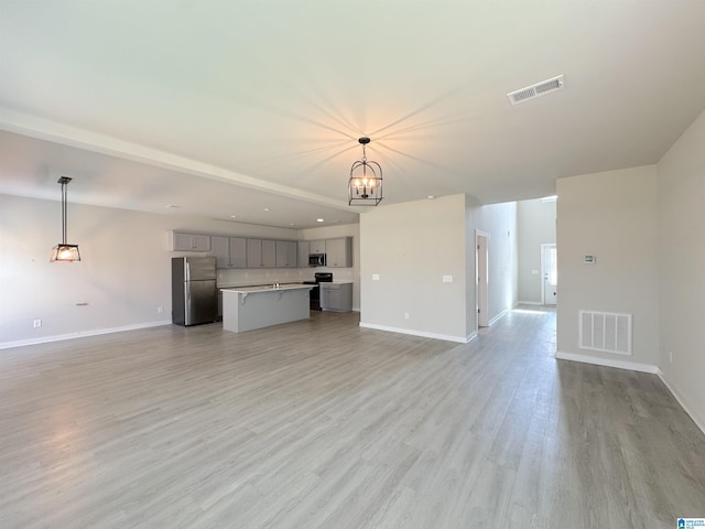115 Ridgeview Cir, Jemison, AL 35085 - unfurnished living room featuring baseboards, a chandelier, and light wood-style floors