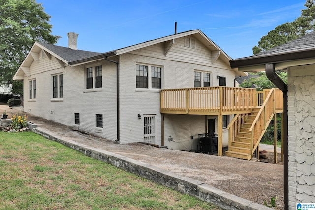 809 15th St W, Birmingham, AL 35208 - rear view of house featuring brick siding, a wooden deck, stairs, central AC unit, and a yard