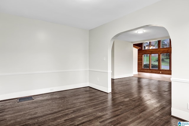809 15th St W, Birmingham, AL 35208 - unfurnished room featuring arched walkways, wood finished floors, and baseboards