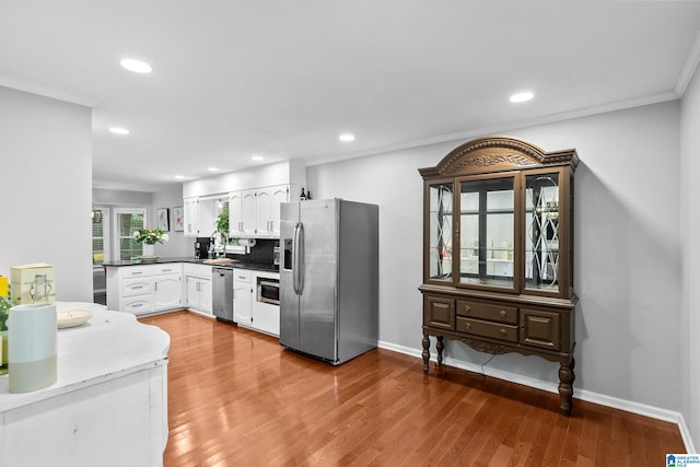 2013 Crossvine Rd, Hoover, AL 35244 - kitchen with stainless steel appliances, white cabinets, ornamental molding, recessed lighting, and light wood finished floors