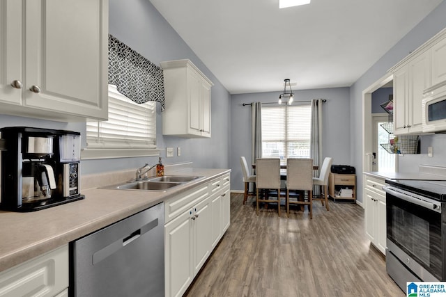 2304 Spaulding Pl, Moody, AL 35004 - kitchen featuring appliances with stainless steel finishes, a sink, light wood-style floors, light countertops, and white cabinetry