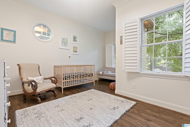 409 Euclid Ave, Mountain Brook, AL 35213 - bedroom featuring a nursery area, baseboards, dark wood finished floors, and crown molding