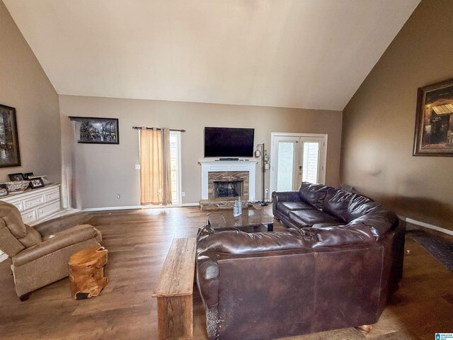 184 Raptor Way, Anniston, AL 36207 - living area with vaulted ceiling, wood finished floors, a stone fireplace, and baseboards