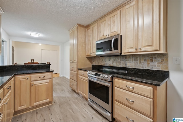 222 Patricia Rd, Madison, AL 35758 - kitchen featuring appliances with stainless steel finishes, light brown cabinetry, light wood-type flooring, a textured ceiling, and backsplash