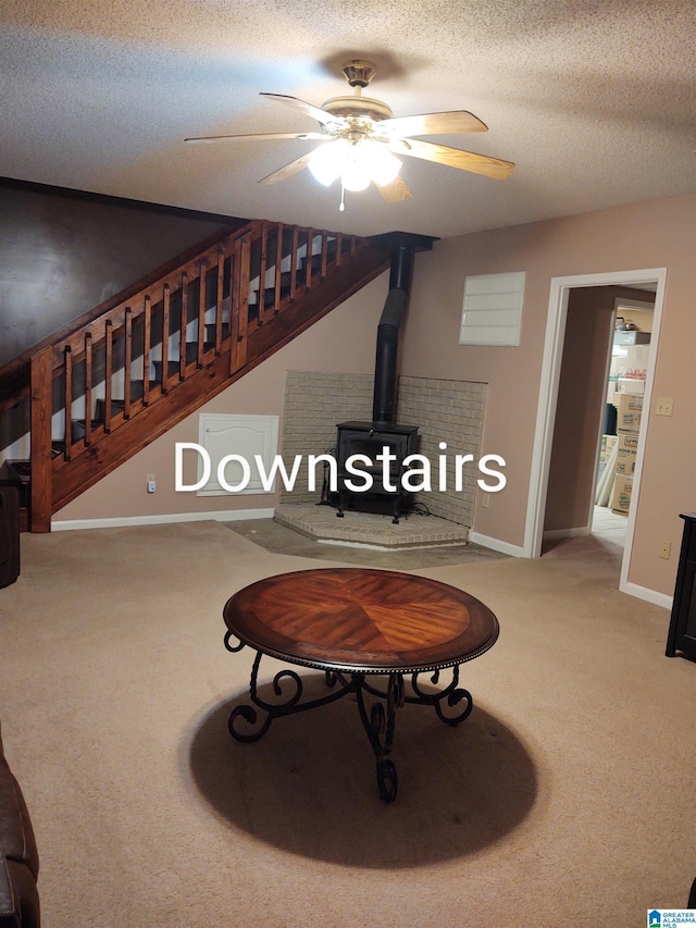 3409 Red Valley Rd, Remlap, AL 35133 - living room featuring a wood stove, carpet flooring, a ceiling fan, stairway, and a textured ceiling