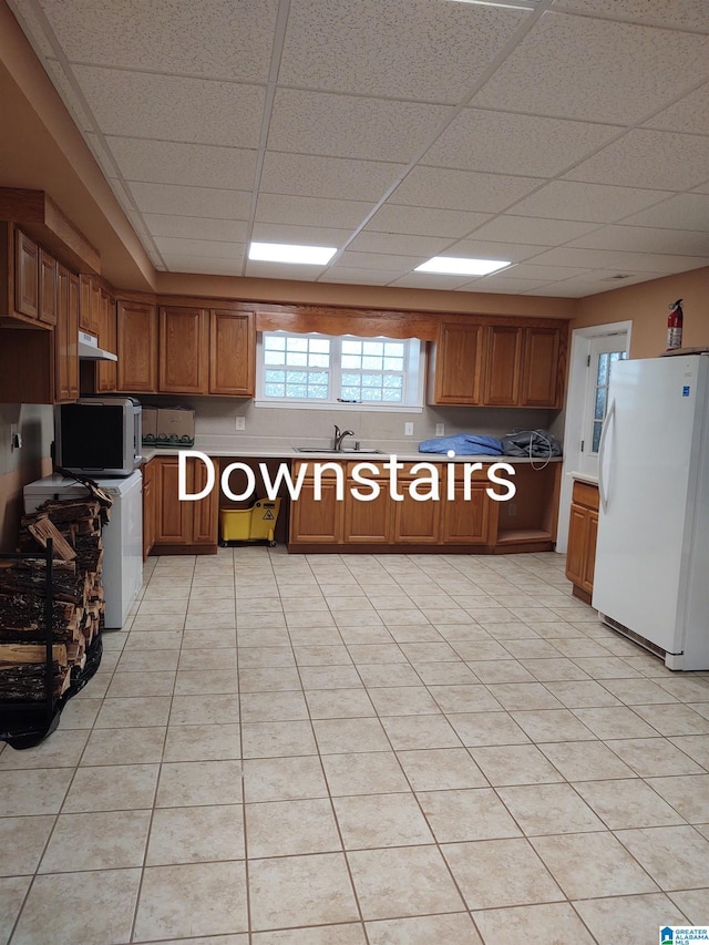 3409 Red Valley Rd, Remlap, AL 35133 - kitchen with freestanding refrigerator, a sink, brown cabinetry, under cabinet range hood, and light countertops