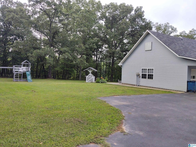 3409 Red Valley Rd, Remlap, AL 35133 - view of home's exterior featuring a playground, a lawn, a shingled roof, and view of wooded area