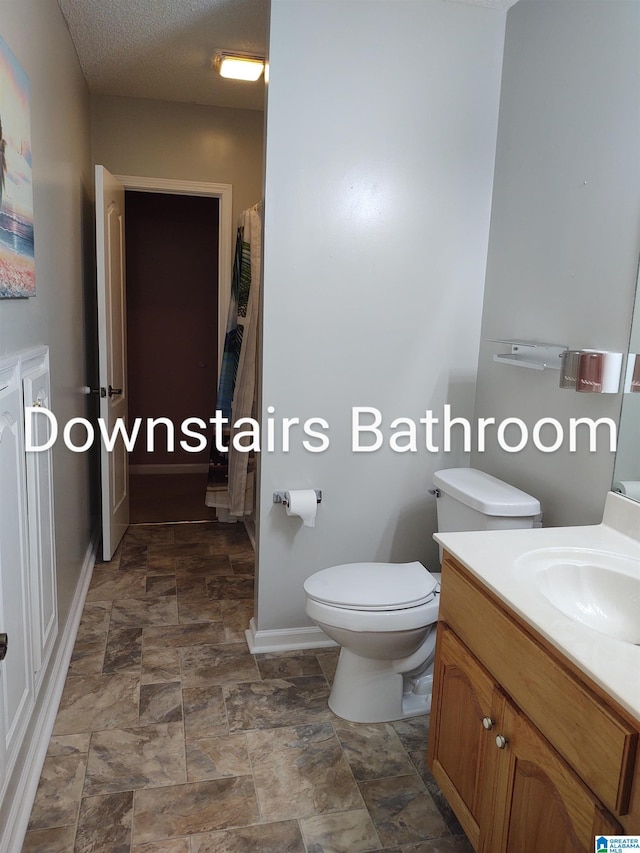 3409 Red Valley Rd, Remlap, AL 35133 - full bathroom with vanity, toilet, baseboards, and stone finish floors