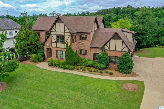 4338 Kings Mountain Rdg, Vestavia Hills, AL 35242 - tudor-style house with brick siding, driveway, a front lawn, stucco siding, and a shingled roof