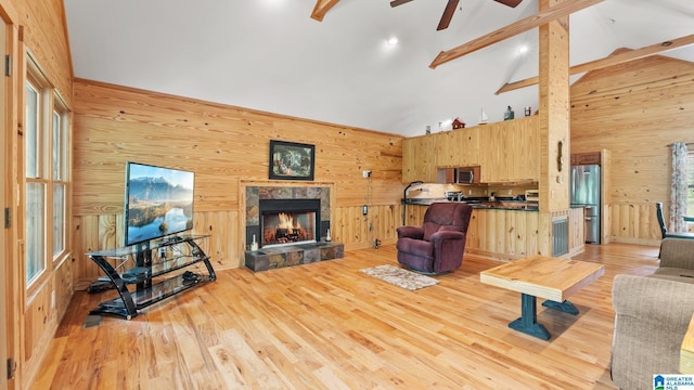 209 Ward Haven Dr, Wedowee, AL 36278 - living area with wood walls, a ceiling fan, light wood finished floors, a stone fireplace, and beamed ceiling