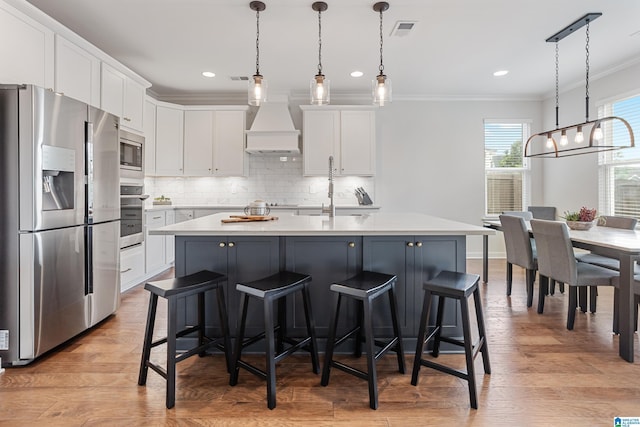 3040 Iris Dr, Hoover, AL 35244 - kitchen featuring appliances with stainless steel finishes, premium range hood, ornamental molding, light countertops, and white cabinets
